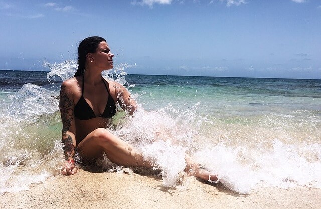 Kobieta w bikini siedząca w wodzie na plaży