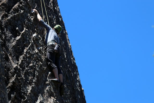 Mężczyzna wspinający się na skałę