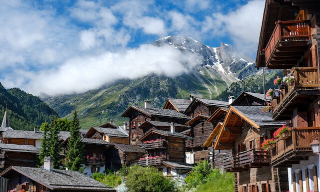 Z czego słynie Szwajcaria? Co warto wiedzieć o Szwajcarii? domy na tle gór