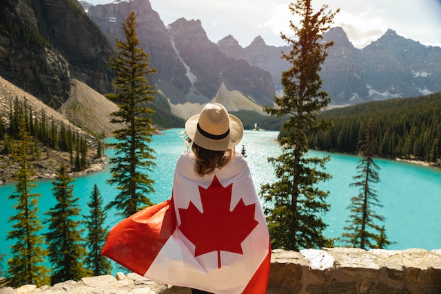 Kobieta z flagą Kanady nad brzegiem jeziora