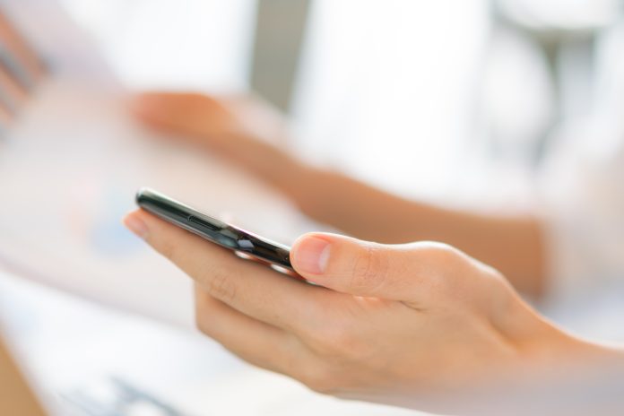 Kobieta trzyma telefon w dłoni